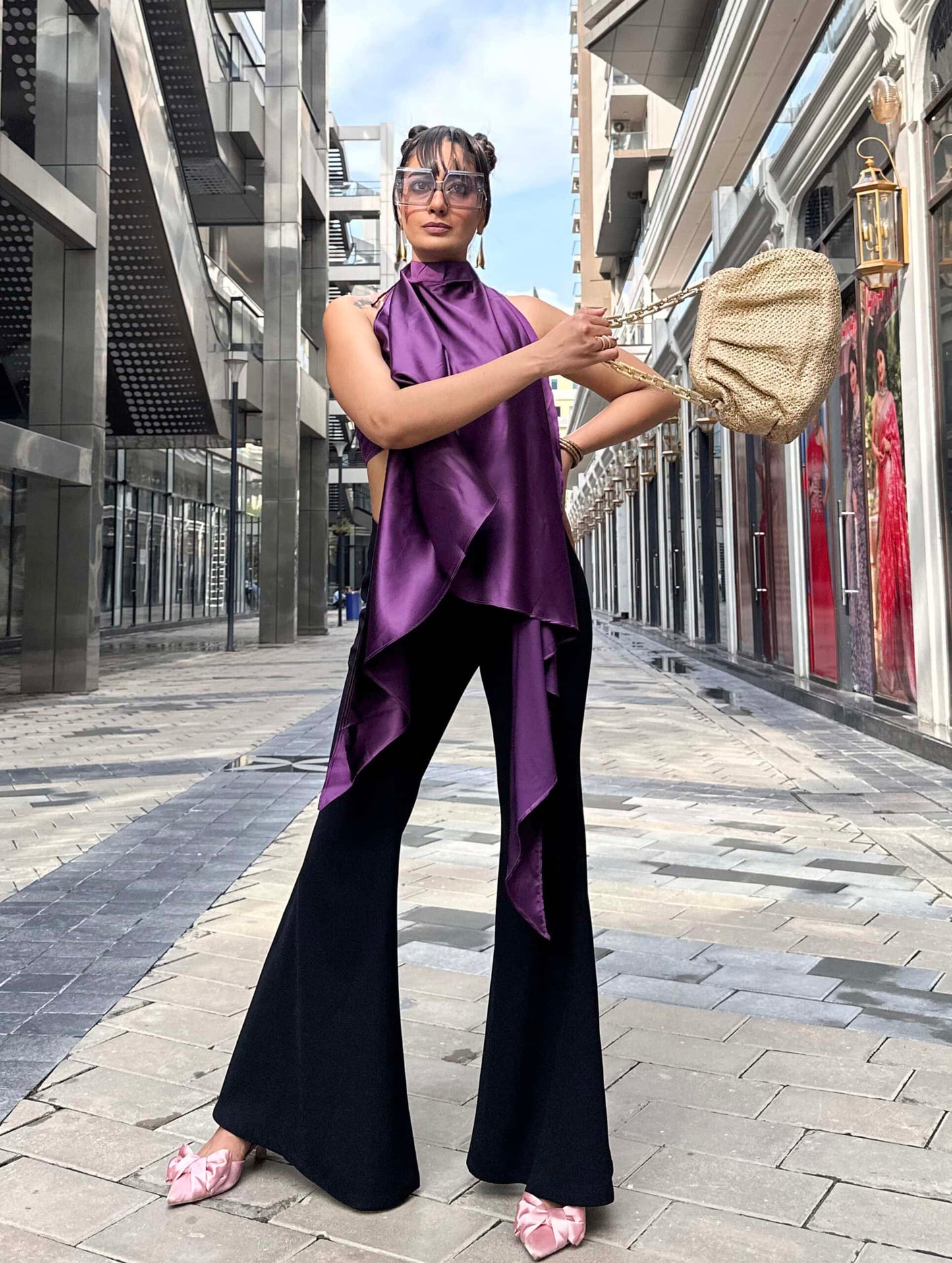 Model wearing a halter neckline cape with button-loop tie, paired with a purple satin bandeau top featuring back smocking for added comfort.