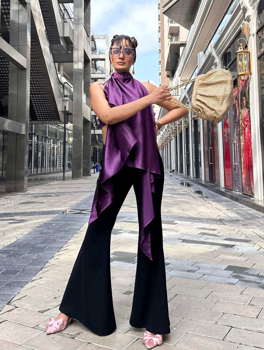 Model wearing a halter neckline cape with button-loop tie, paired with a purple satin bandeau top featuring back smocking for added comfort.